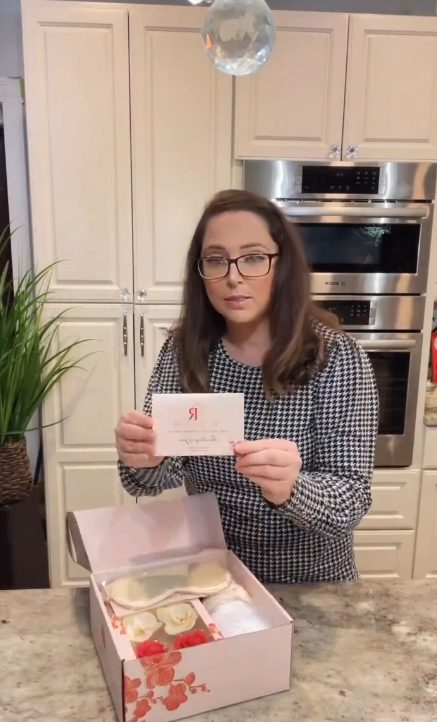 Creator holding a card from a gift box during an unboxing