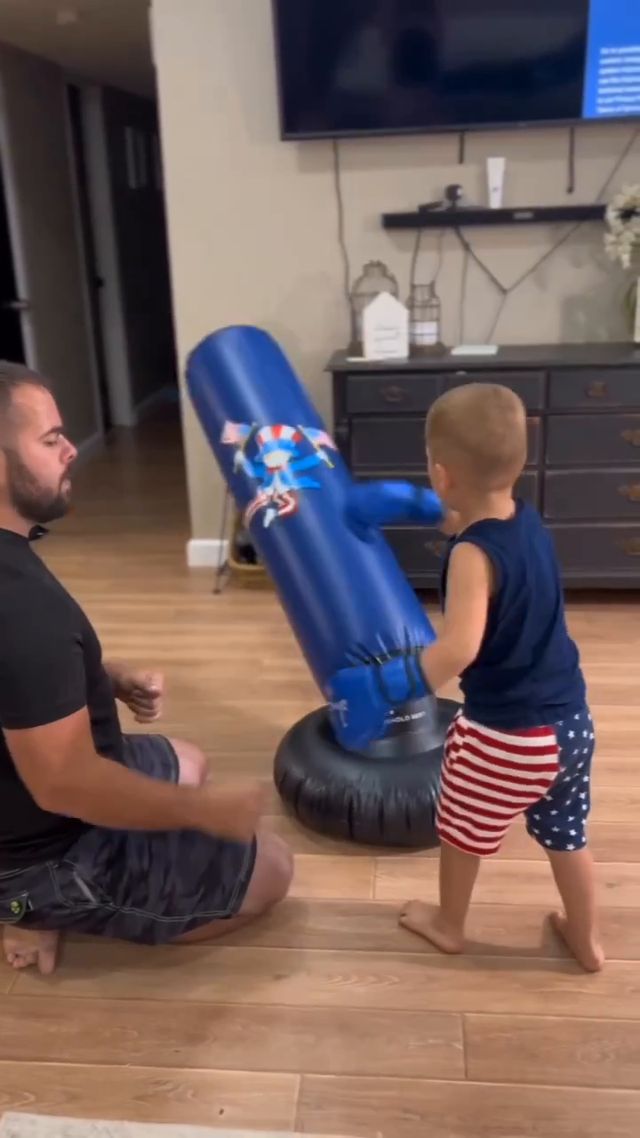 Child using a free-standing punching bag in a living room